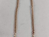 a close up of a gold chain with a ring on it