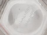 a glass vase with a label on it sitting on a table