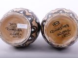 two vases with writing on them sitting side by side