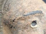 a close up of a clay head with a hole in it
