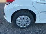 une petite voiture blanche garée sur le bord de la route