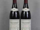 two bottles of wine sitting on top of a table next to each other