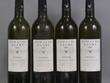 four bottles of wine are lined up on a table