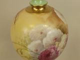 a green vase with a floral design on it