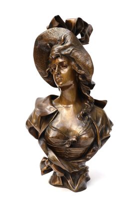 bronze bust of a woman wearing a hat and a dress