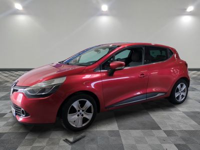 une voiture rouge est garée dans une pièce au sol en damier