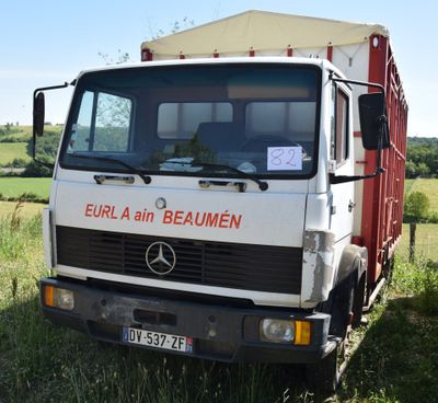 a truck that is parked in the grass in the field