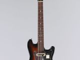 an electric guitar hanging from a string on a wall