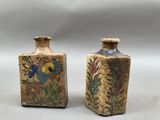 une paire de petits vases ornés de motifs floraux sur fond blanc