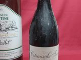two bottles of wine sitting next to each other on a table