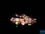 a pile of multicolored crystals on a black surface