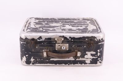une valise noire et blanche posée sur une surface blanche