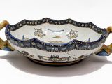 a blue and white bowl with handles on a white surface