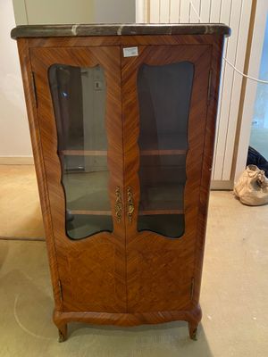 a wooden cabinet with a glass door in a room