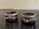 pair of purple glass candlesticks on a black marble table