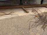 a pile of steel rods on the ground in front of a building