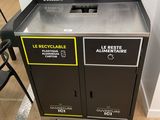 two trash bins that are sitting on the floor