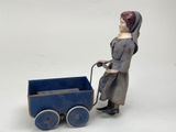 a toy doll that is pushing a blue toy stroller