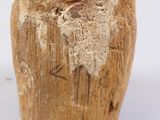 a close up of a piece of wood with a face carved into it