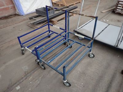 un chariot bleu posé par terre à côté d'une pile de palettes