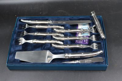 four knives in a blue box on a table