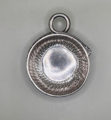 silver plated pendant with a circular design on the front of it