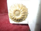 a gold flower brooch sitting on a red chair