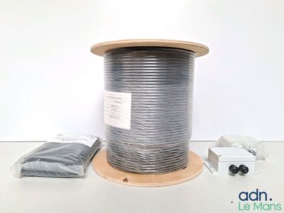 une bobine de fil d'argent posée sur une table blanche