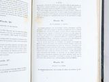 an open book on a white surface with a black border