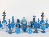 de nombreux vases en verre bleu posés sur une surface blanche