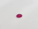 a pink oval shaped stone on a white surface