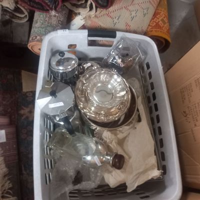 a basket full of glass items sitting on the floor