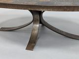 a large metal table with a circular top on a white floor