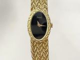 a gold bracelet watch with a black face and a gold chain strap