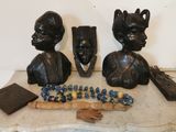 deux statues représentant des personnes assises sur une table avec un morceau de bois