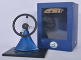 une horloge bleue avec un volant devant une boîte bleue