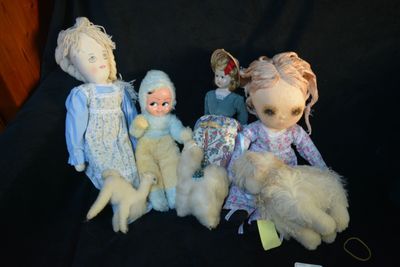 five dolls sitting next to each other on a black cloth