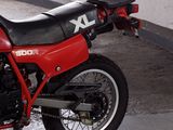 a red and black motorcycle parked in a garage