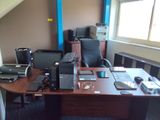 un bureau sur lequel se trouvent un ordinateur, une imprimante et d'autres appareils électroniques
