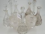 Plusieurs vases en verre transparent sont alignés sur une surface blanche