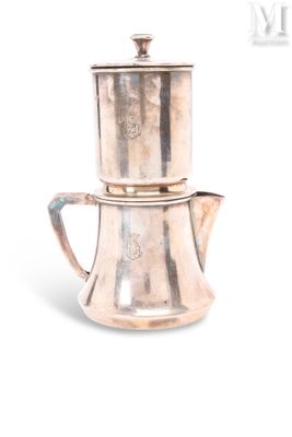 une cafetière en argent posée sur une théière en argent