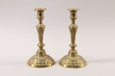 pair of antique brass candlesticks on a white background