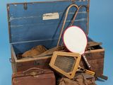 Plusieurs valises et une raquette de tennis sont posées sur une surface bleue