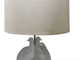 a white lamp with two birds on it on a table