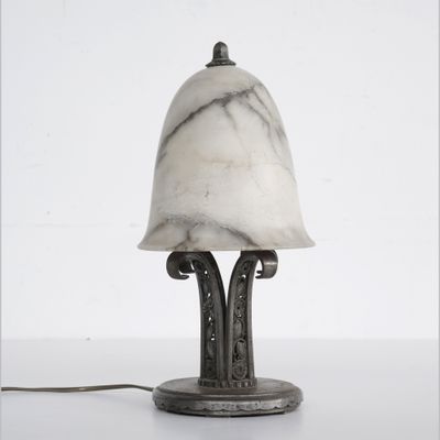 une lampe posée sur une table à côté d'un mur blanc