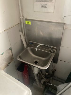 un lavabo dans un coin d'une petite salle de bains