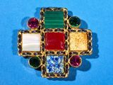 a close up of a colorful broochle on a blue surface