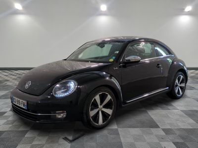 une photo d'une Coccinelle Volkswagen noire garée dans un garage