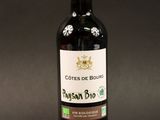 a bottle of red wine on a black background