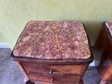 two wooden tables with marble top on them in a room
